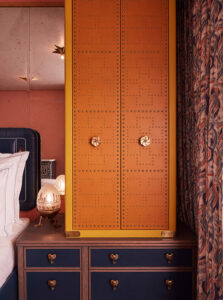 On the table rests a red and yellow combination safe, complemented by an oval-shaped night lamp.