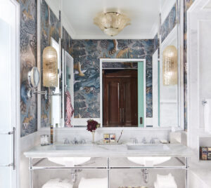 Flawless white marble washbasin with fragrance, adorned by a small flower stand. Neatly arranged towels below.