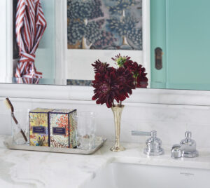 Pristine white marble washbasin with fragrance and small flower stand, creating a refreshing atmosphere.