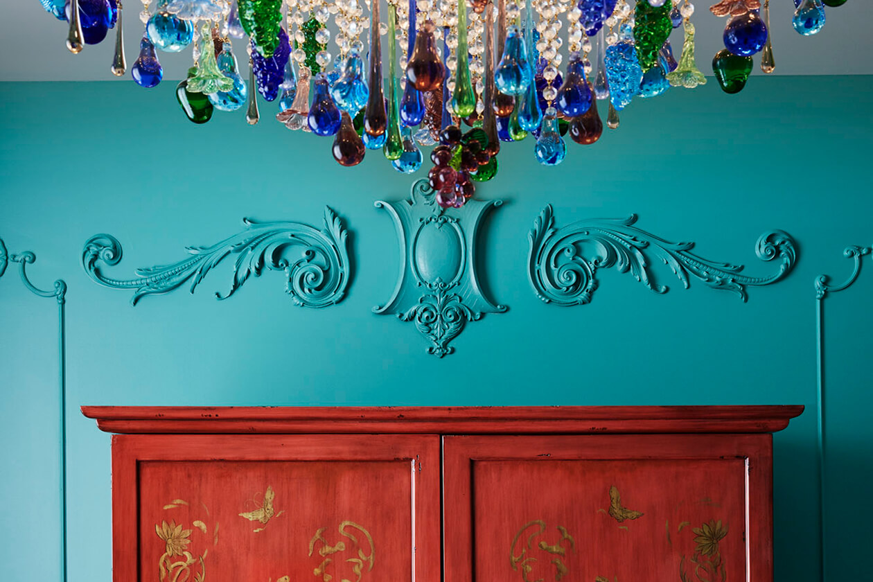 Elegant wall design above wardrobe, adorned by a chandelier suspended from the ceiling.