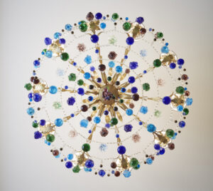 Crystal-adorned chandelier suspended gracefully from the ceiling, enhancing the space with elegance.