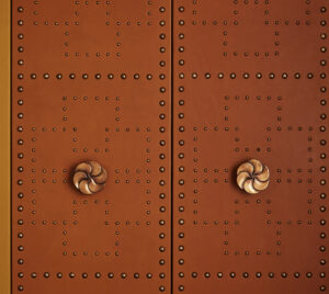 The wardrobe door adorned in red, featuring a handcrafted door handle adding artistic flair.