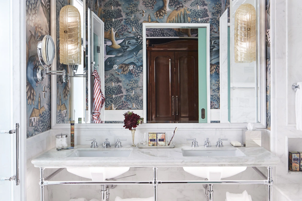 Pristine white marble washbasin with fragrance and small flower stand, creating a refreshing atmosphere.