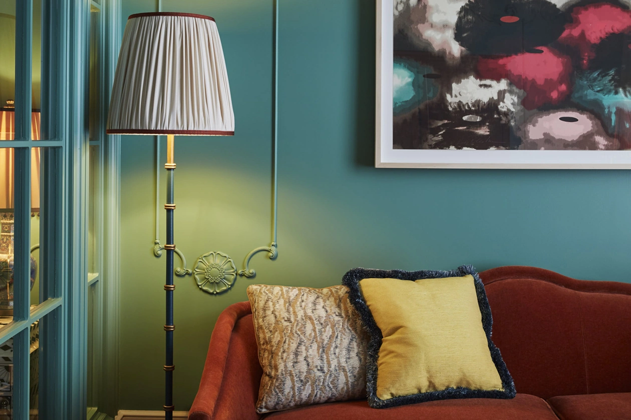 Standing lamp near the couch, wall adorned with a portrait just above, creating a harmonious ambiance.