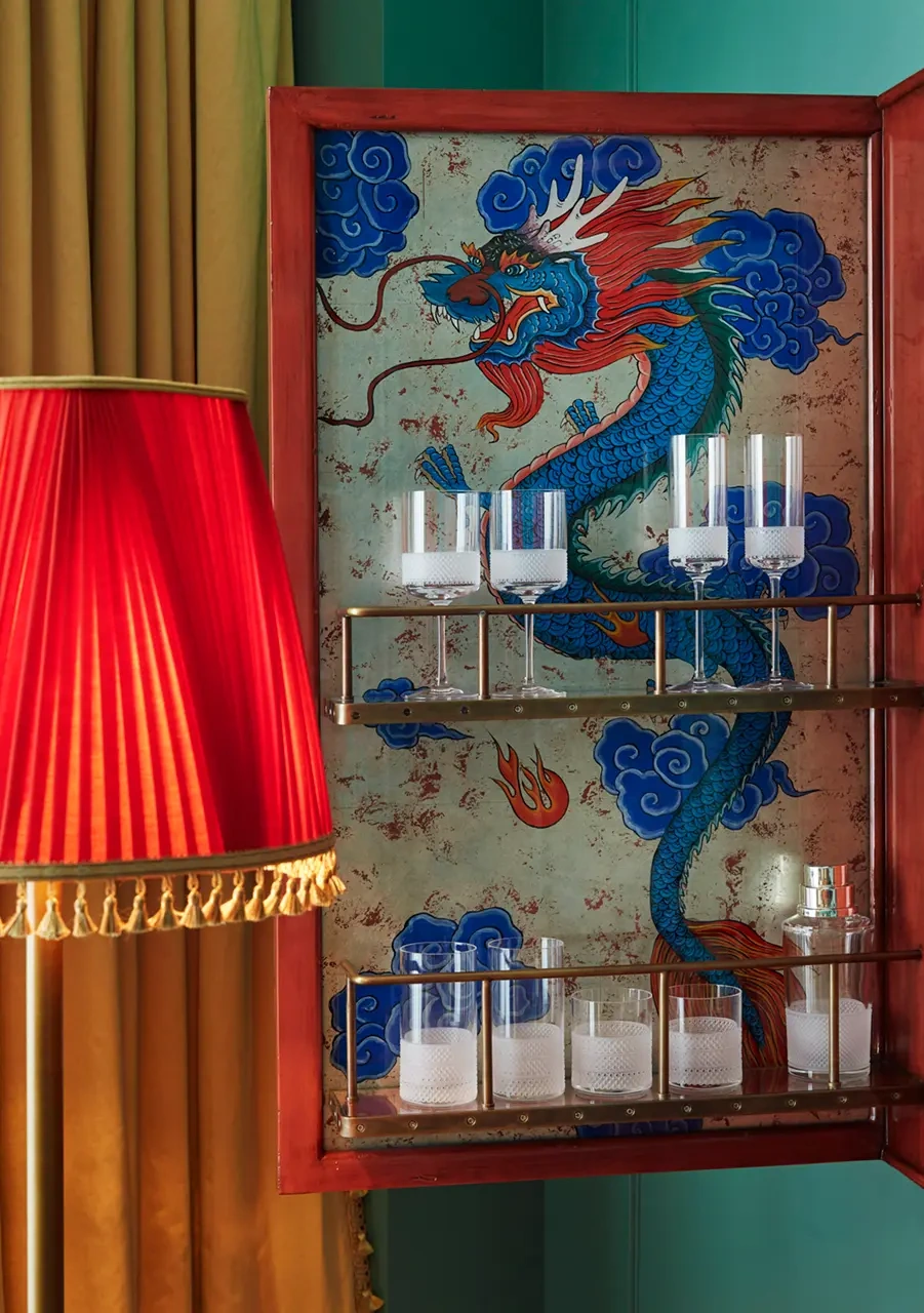 Various crystal wine glasses are neatly arranged on the rack, complemented by a dragon painting backdrop.