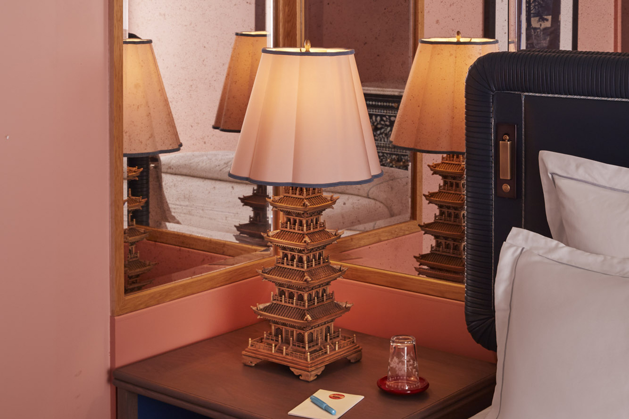 Antique lamp handcrafted and positioned on the bedside table, its reflection captured in the mirror.