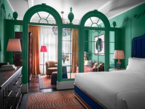 Tastefully organized bedroom: bed with table lamp, sofa set near the window, creating inviting ambiance.