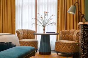Table beside two sofas, showcasing a charming vase, a notebook, and a standing lamp nearby.