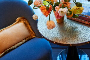Beside the couch, a table adorned with a lovely flower vase and notebooks.