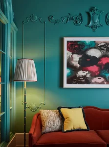 Next to the couch, a standing lamp and a portrait blend harmoniously on the wall.