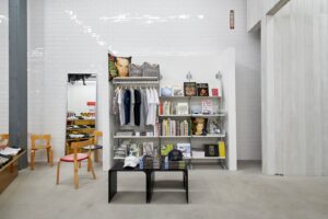 Shelves neatly arranged with T-shirts and books create an organized display.