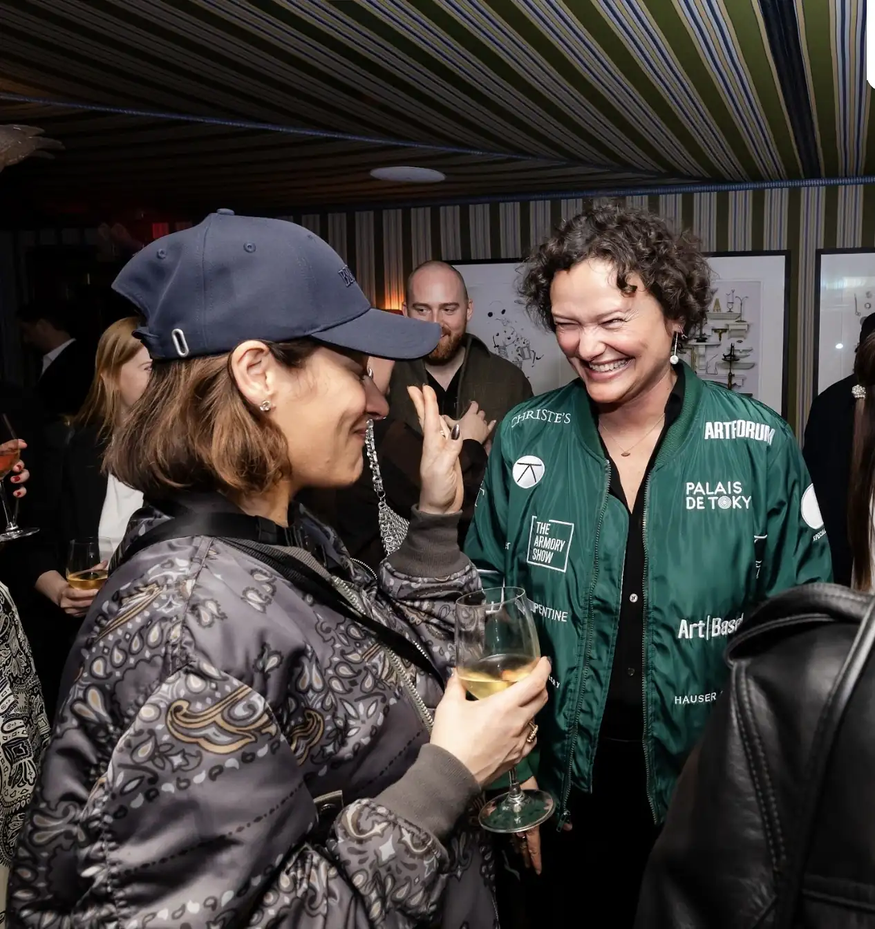 A group of people gathered, laughing and enjoying a lively conversation in a warm and cheerful setting
