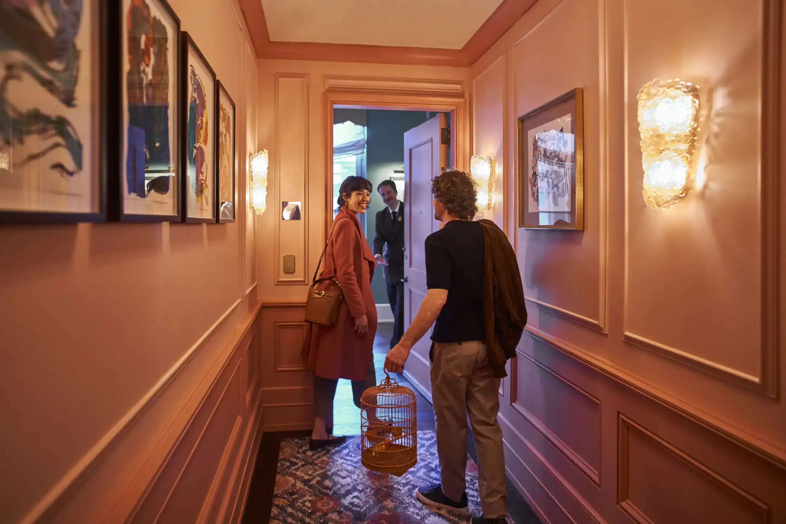 A couple is about to enter their room while someone waits for them.