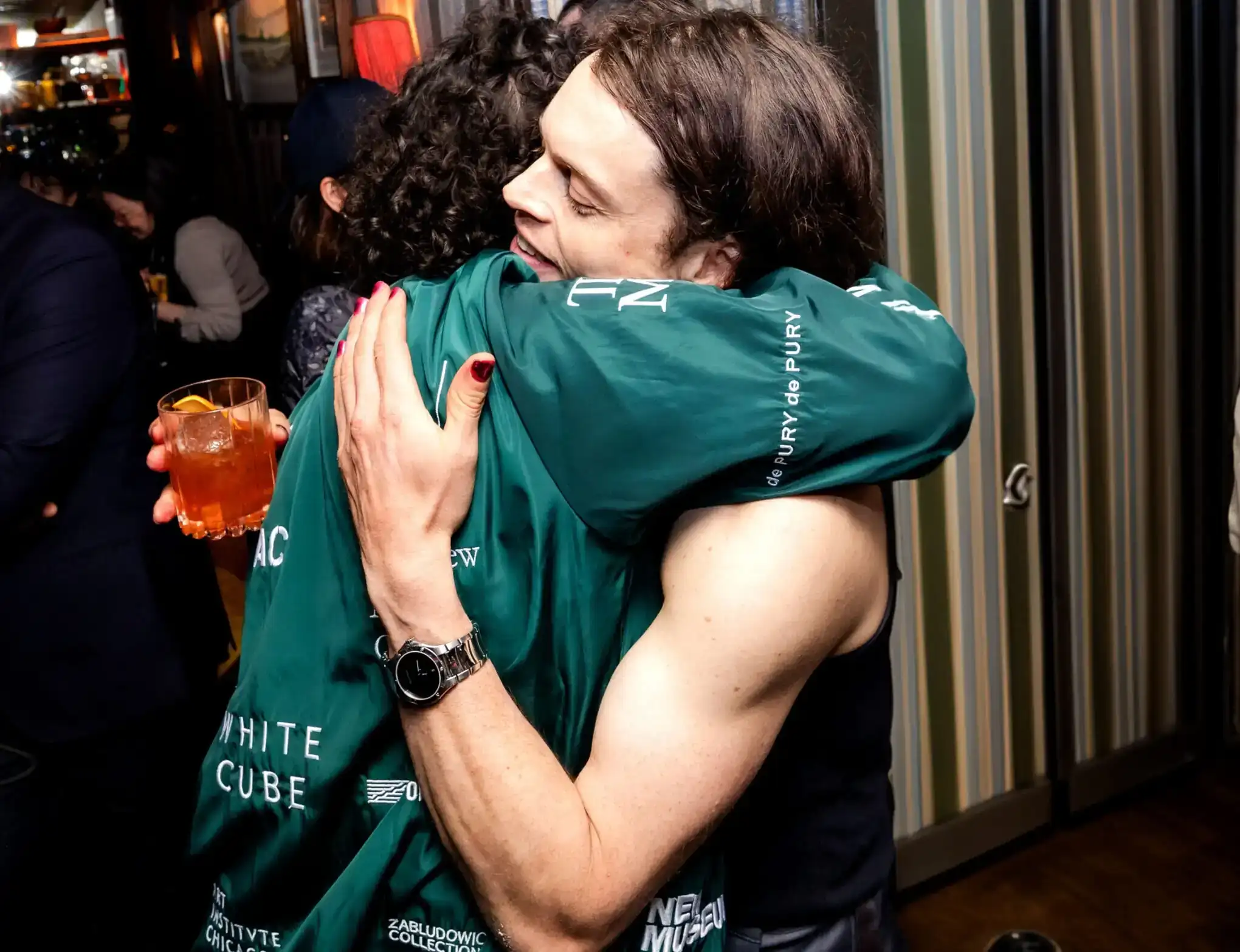 Two men are hugging each other while enjoying the party at the club.