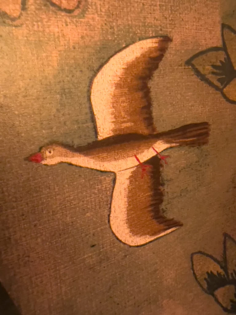 A stunning bird painting is beautifully displayed on the wall, adding vibrant charm.