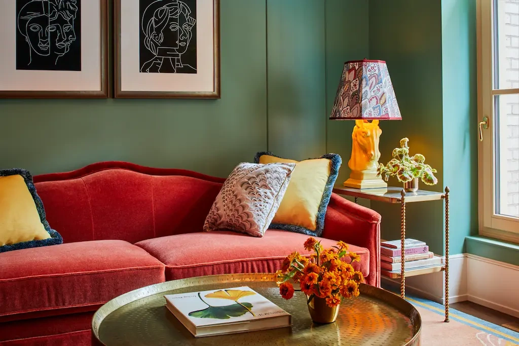 A well-arranged sofa set in the living space with two beautiful portraits mounted above.