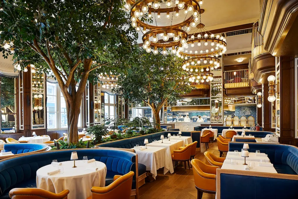 The restaurant's beautifully arranged dining area is illuminated by two large chandeliers.