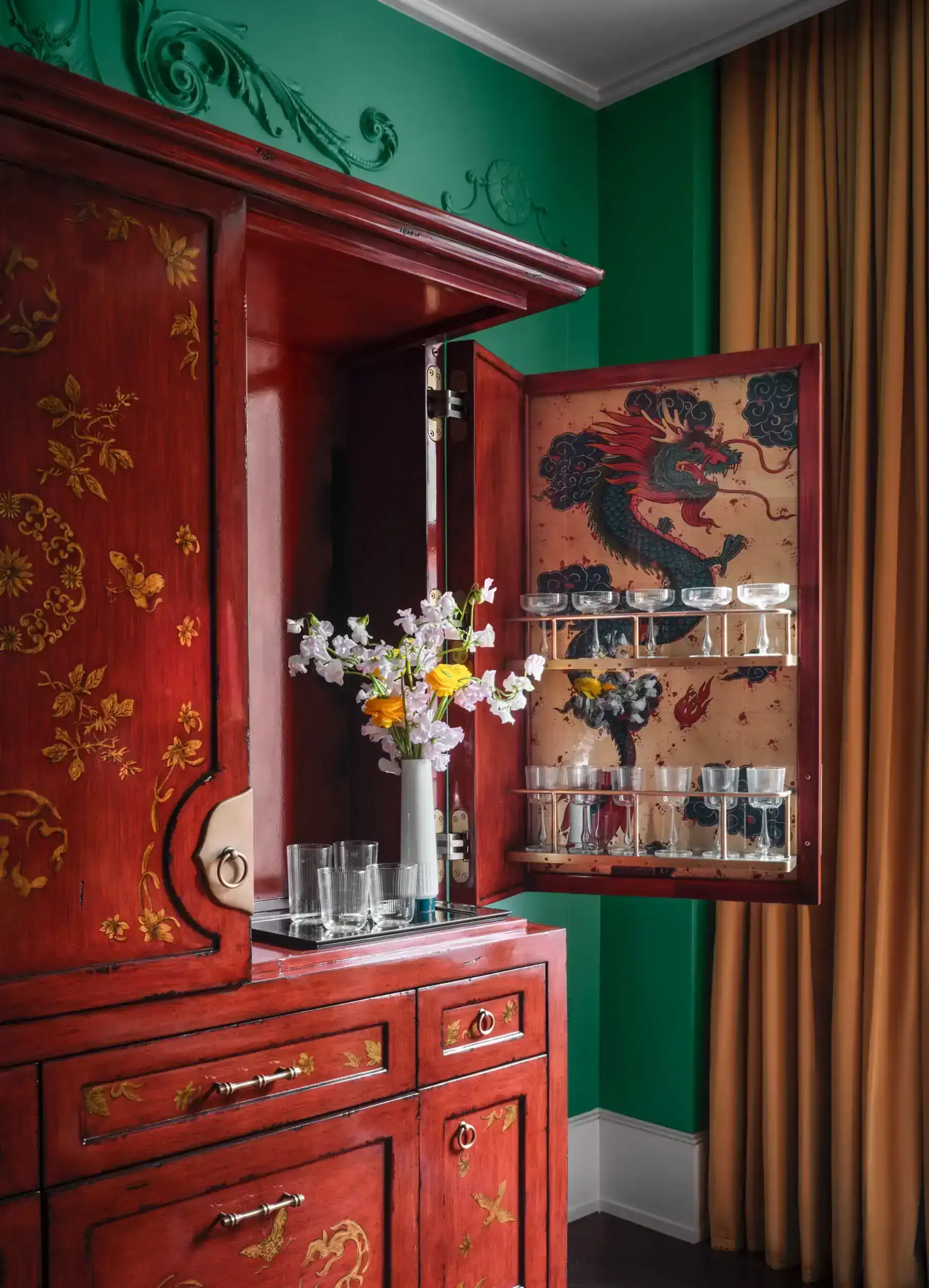 Beautifully arranged glasses in the cupboard shelves, with a small flower pot on them.