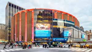 The impressive architectural design of Madison Square Garden features a billboard displaying information.