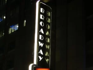 A glowing signboard displays the text "BROADWAY."