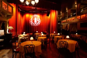 A well-arranged dining area with numerous chairs and tables, each illuminated by a small lamp.
