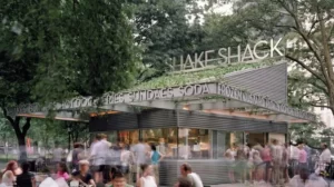 People are waiting for their orders at the "Shake Shack Soda" counter.