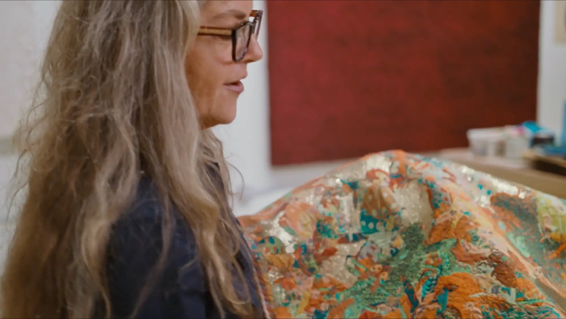 A woman presenting the fabrics she creates in her mini-documentary PAE WHITE, BUGZ AND DRUGS