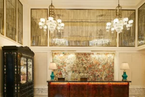 Two beautifully designed lamps on the table and two chandeliers illuminate the room.