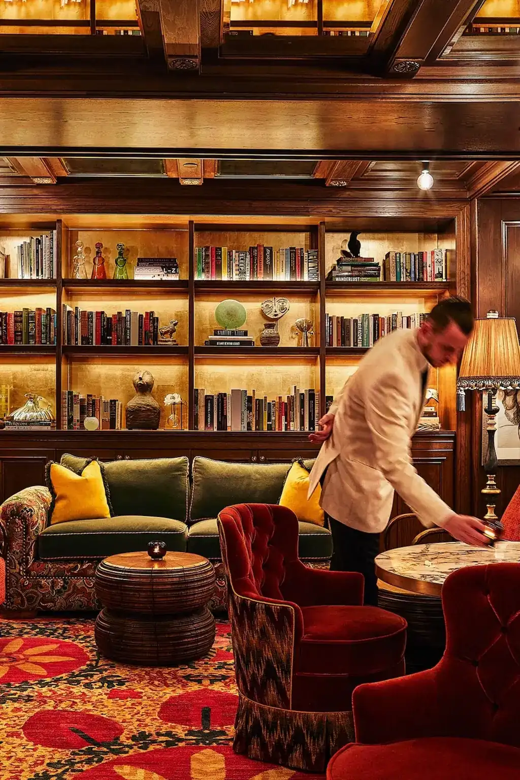 "A waiter elegantly serving guests at The Fifth Avenue hotel café, delivering impeccable service in a refined setting