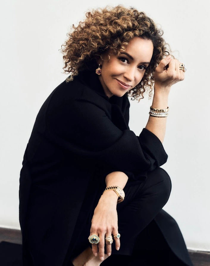 A woman elegantly posing with sparkling jewelry, showcasing sophistication and style
