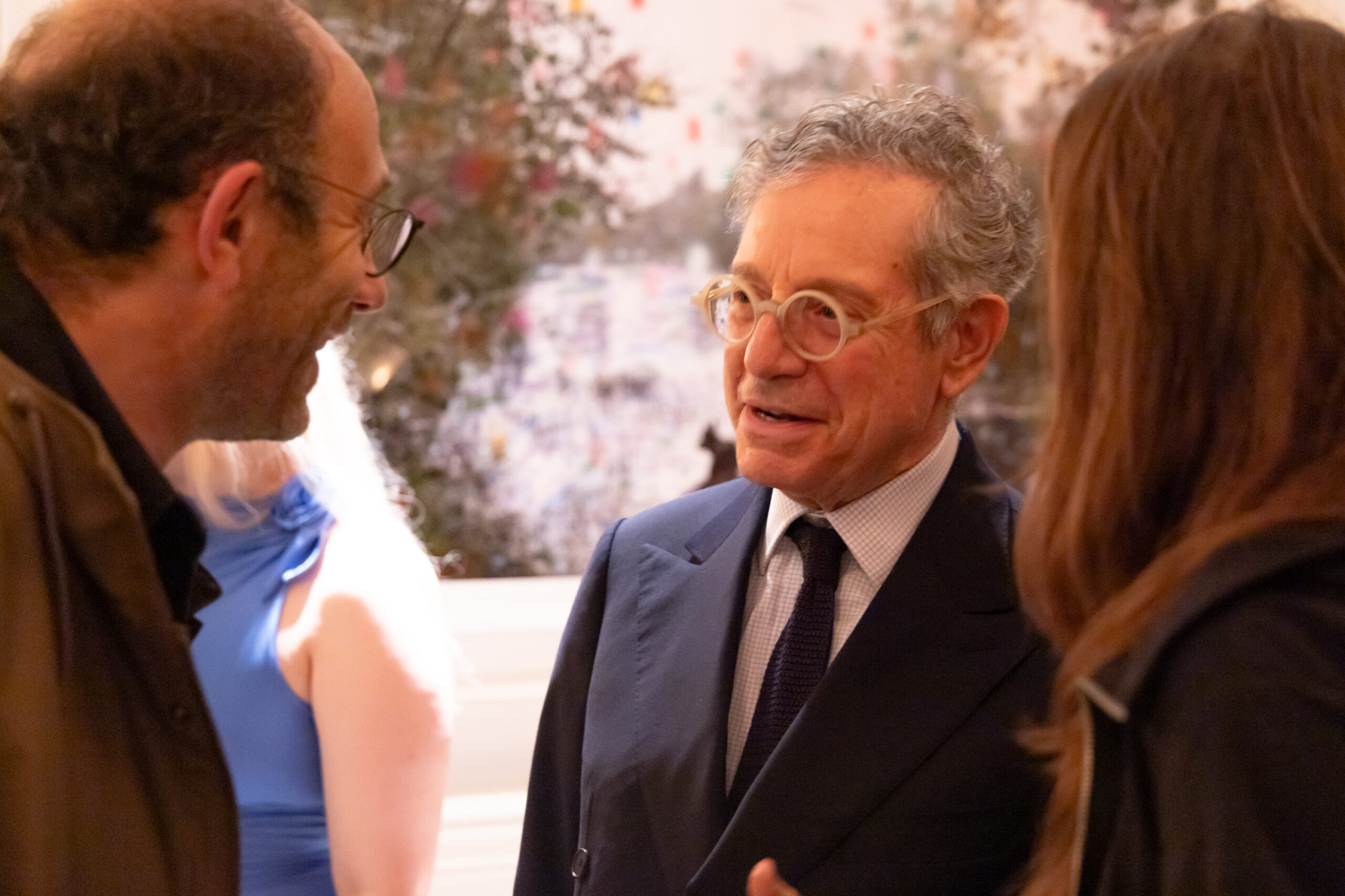 Professionals engaged in a lively discussion at a Frieze meeting, exchanging ideas in an elegant setting