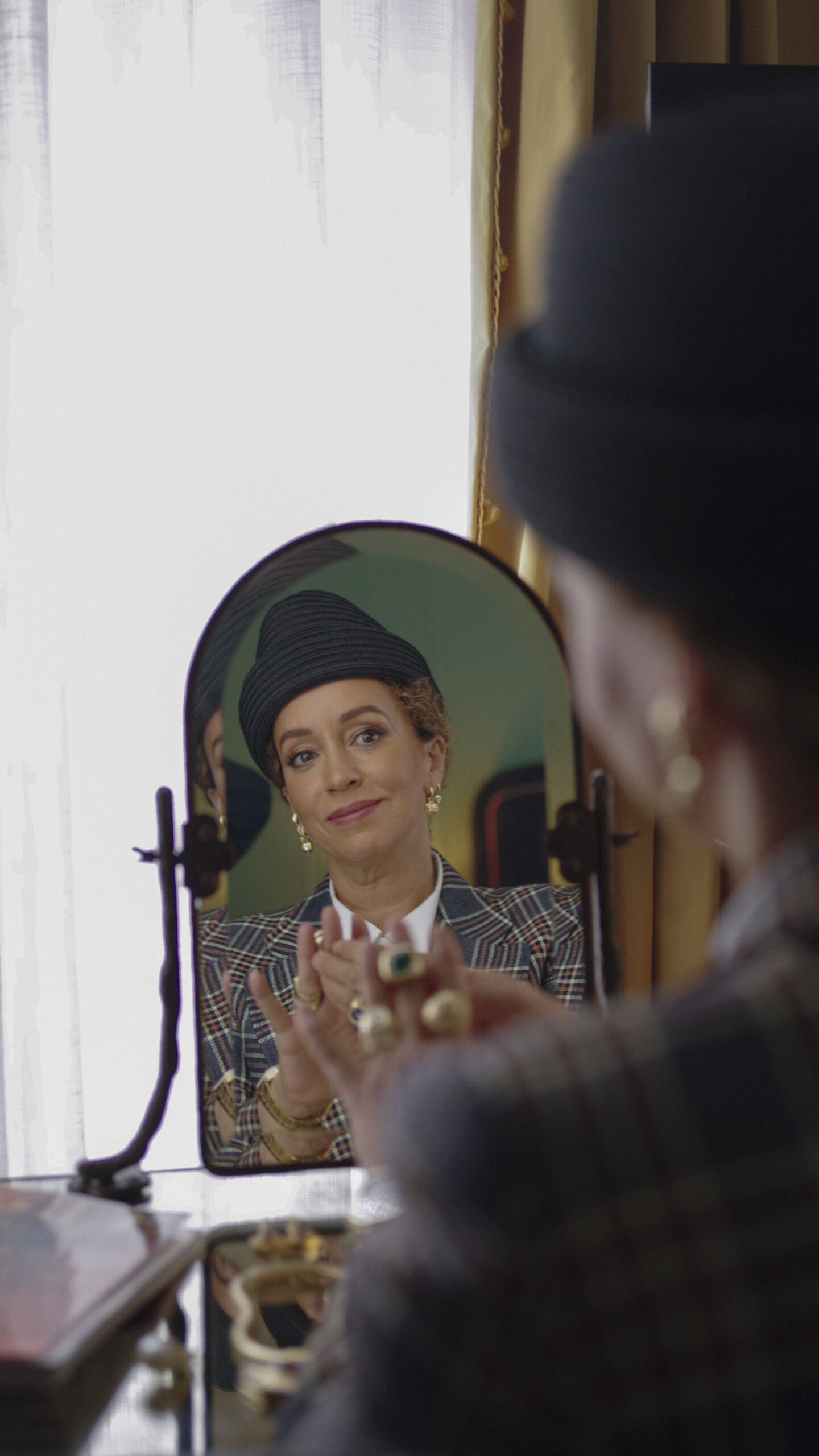 A woman elegantly dressing for work at The Fifth Avenue hotel adjusting her outfit with confidence.