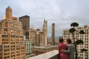 Pair gazes at the city's beauty from the rooftop, savoring the panoramic view.